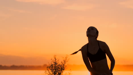 Schönes-Volleyballmädchen-Im-Bikini-Bei-Sonnenuntergang,-Unterarmpass-Mit-Ihrer-Teamkollegin-Während-Eines-Spiels